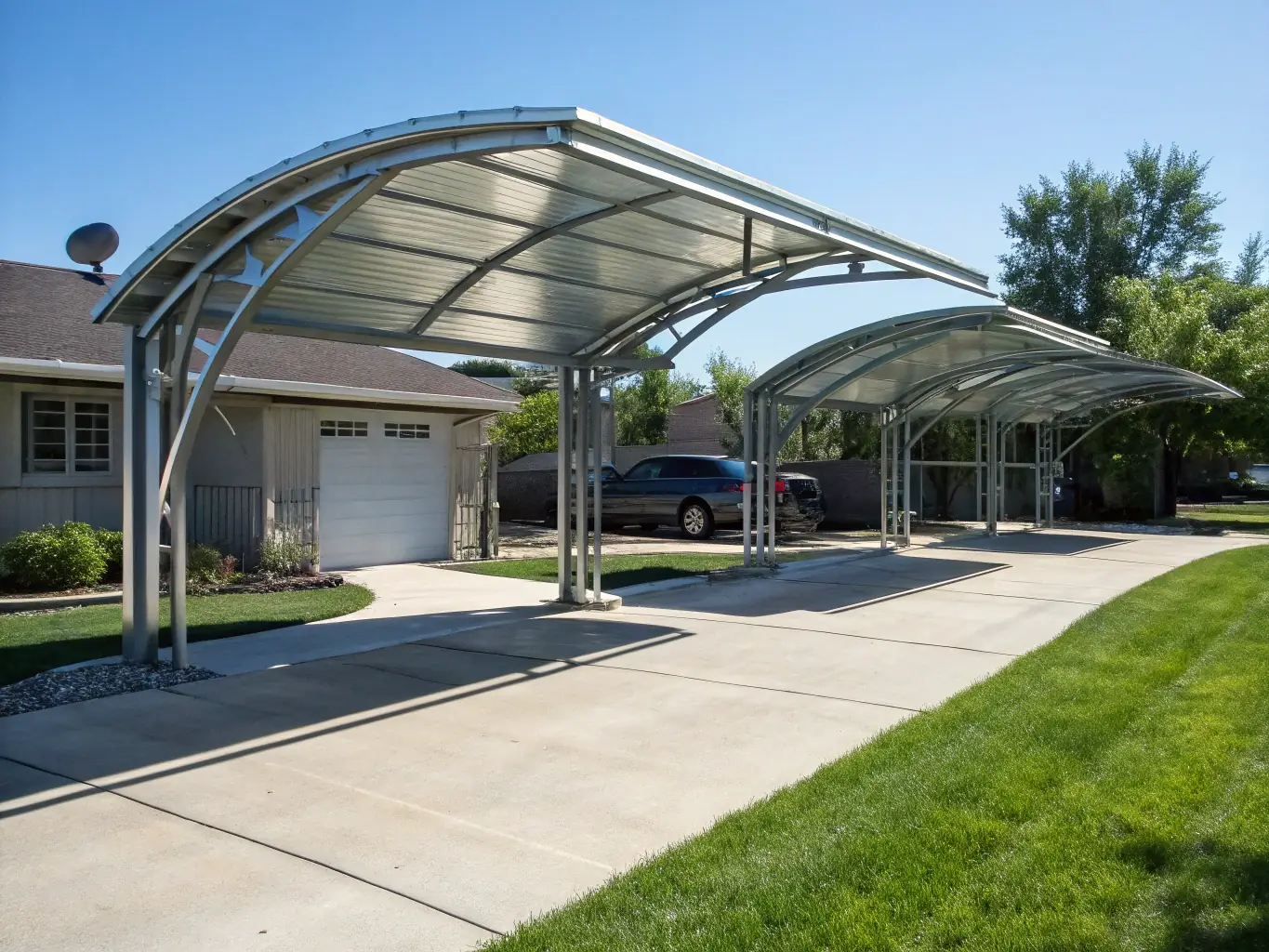 A sturdy steel carport protecting two vehicles from the elements, emphasizing its reliability and practicality. The carport is set against a residential backdrop, showcasing its seamless integration with existing properties.